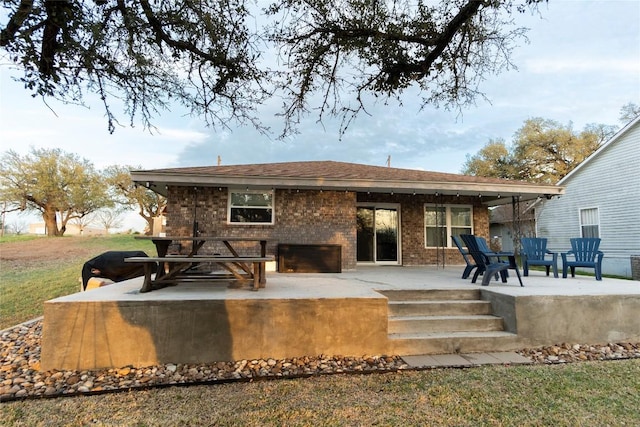 back of house featuring a patio area and brick siding