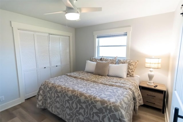 bedroom featuring ceiling fan, a closet, wood finished floors, and baseboards