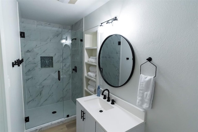 bathroom with a shower stall and vanity