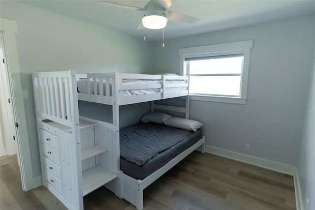 bedroom with ceiling fan, baseboards, and wood finished floors