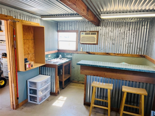 interior space featuring a bar, a sink, concrete flooring, and a wall mounted AC