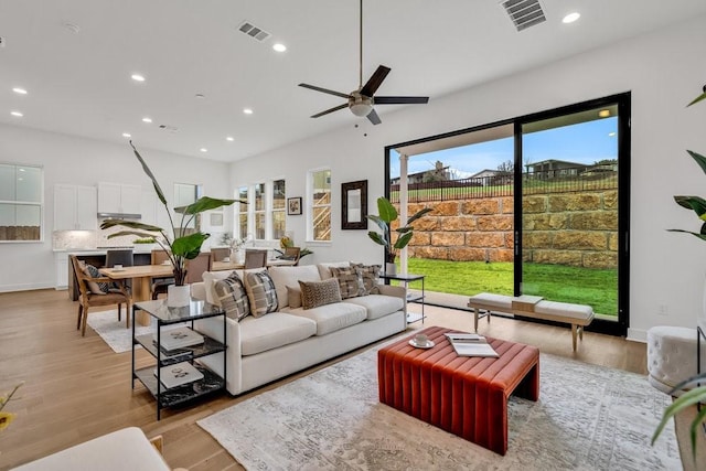 living room featuring recessed lighting, visible vents, and light wood-style flooring