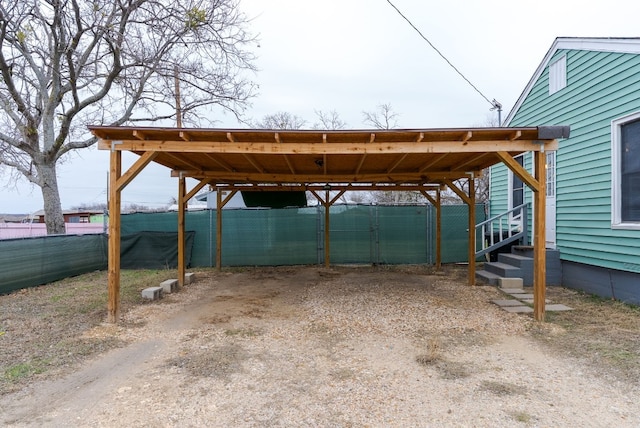 view of parking / parking lot featuring a carport and fence