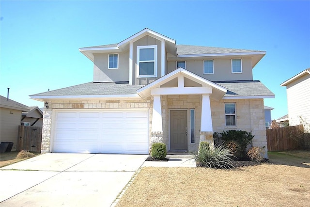 view of front of house featuring driveway, stone siding, fence, and board and batten siding