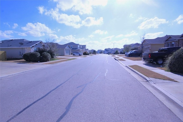116 Four Star Dr, Elgin, TX 78621 - view of asphalt road with a residential view, sidewalks, street lighting, and curbs