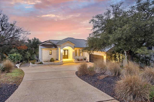 17813 Kingfisher Ridge Dr, Lago Vista, TX 78645 - view of front of home with a standing seam roof, driveway, metal roof, and an attached garage