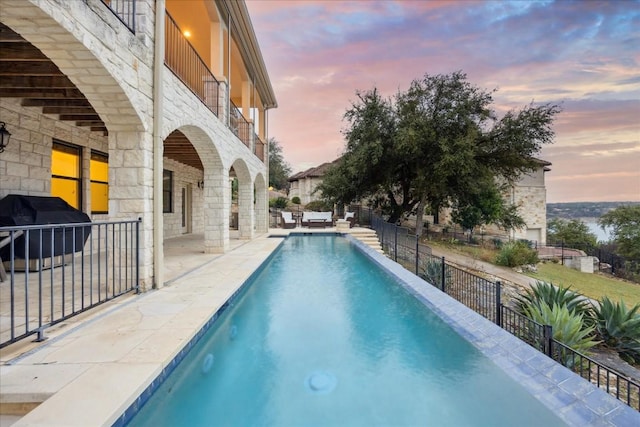 17813 Kingfisher Ridge Dr, Lago Vista, TX 78645 - pool at dusk with area for grilling and a patio