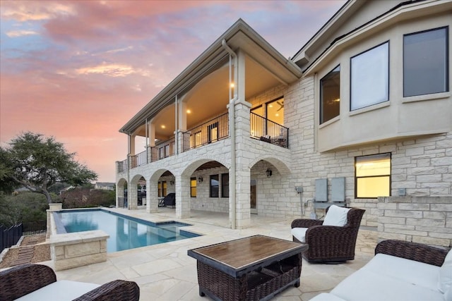 17813 Kingfisher Ridge Dr, Lago Vista, TX 78645 - rear view of property with a balcony, stone siding, a patio area, and an outdoor pool