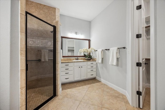 17813 Kingfisher Ridge Dr, Lago Vista, TX 78645 - bathroom featuring a walk in closet, vanity, a shower stall, tile patterned flooring, and baseboards