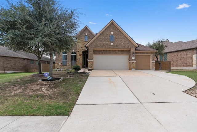 traditional-style home featuring driveway, a garage, stone siding, fence, and brick siding