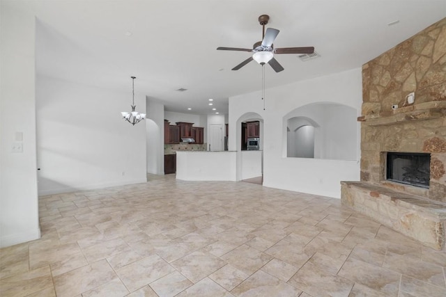 unfurnished living room with recessed lighting, visible vents, a stone fireplace, and ceiling fan with notable chandelier