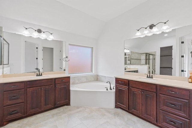 full bathroom featuring lofted ceiling, a garden tub, a sink, and a shower stall