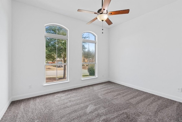 carpeted empty room with baseboards, a ceiling fan, and a healthy amount of sunlight