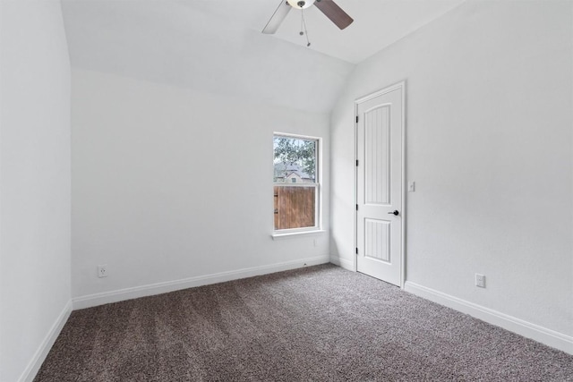 empty room featuring lofted ceiling, carpet floors, a ceiling fan, and baseboards