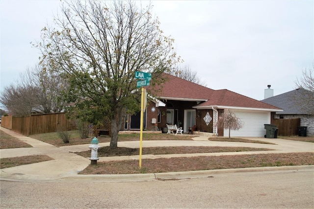 ranch-style house with a garage, brick siding, a shingled roof, fence, and driveway