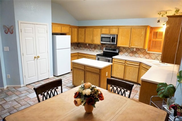 kitchen with light countertops, appliances with stainless steel finishes, a sink, and decorative backsplash