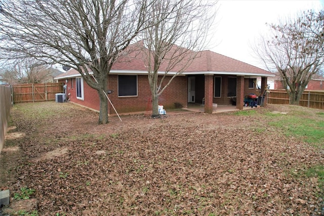 back of property with a patio area, brick siding, and a fenced backyard