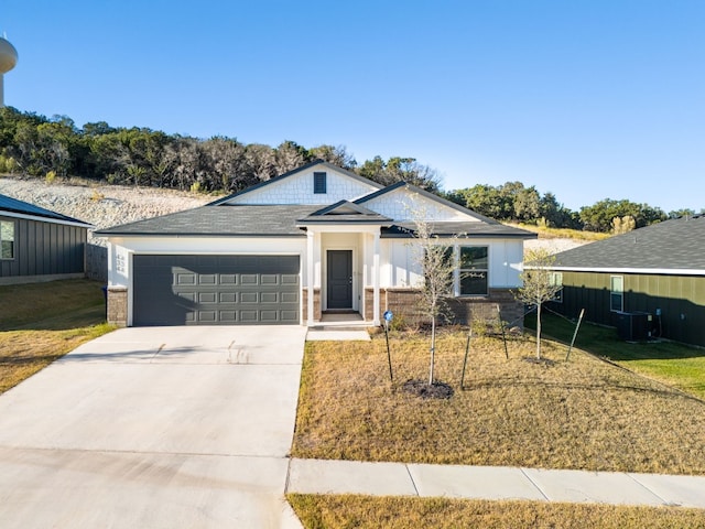 single story home featuring central air condition unit, a garage, brick siding, concrete driveway, and a front lawn