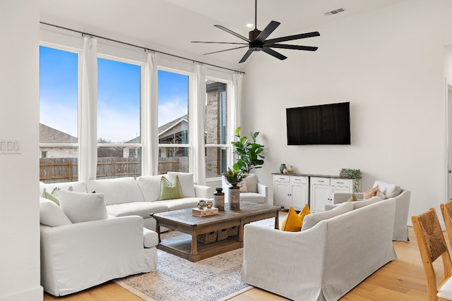 living area with light wood-type flooring, a ceiling fan, and visible vents