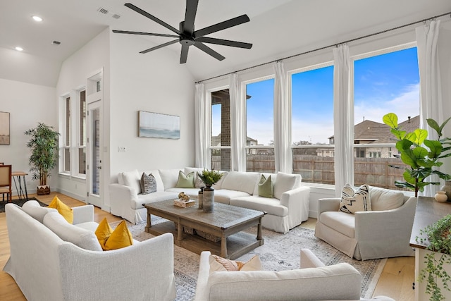 living room featuring light wood-style floors, a ceiling fan, visible vents, recessed lighting, and lofted ceiling