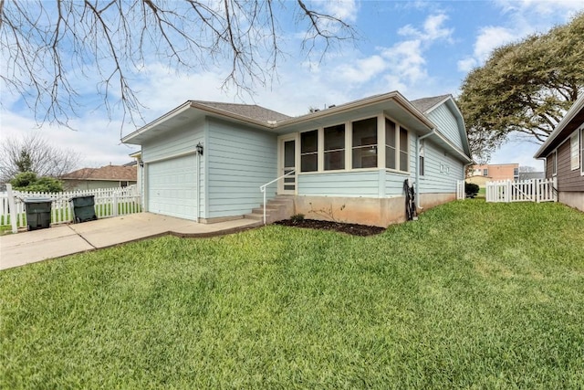 view of front of property with a sunroom, driveway, a front lawn, and an attached garage