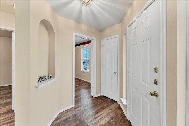 entrance foyer featuring dark wood-style flooring and baseboards