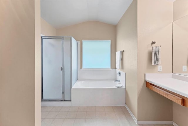 bathroom featuring vaulted ceiling, a stall shower, a bath, and baseboards