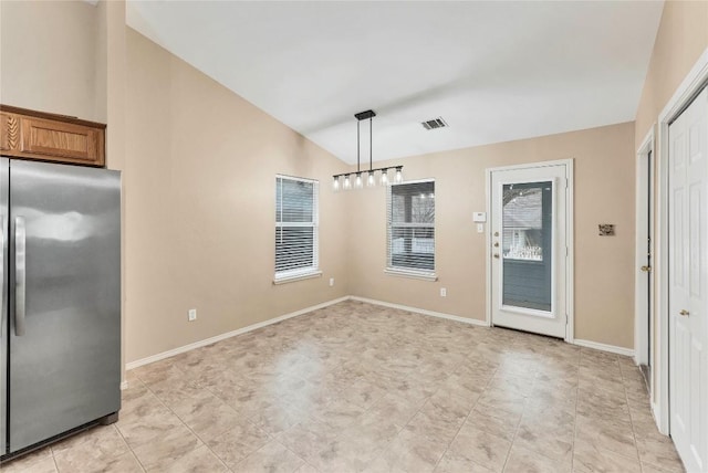 unfurnished dining area with baseboards, visible vents, and vaulted ceiling