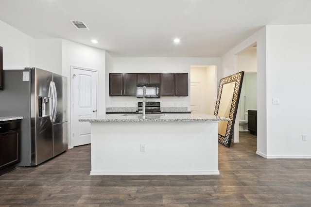 kitchen featuring black microwave, a kitchen island with sink, a sink, visible vents, and stainless steel fridge with ice dispenser