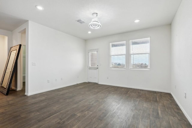 unfurnished room featuring visible vents, baseboards, dark wood finished floors, and recessed lighting
