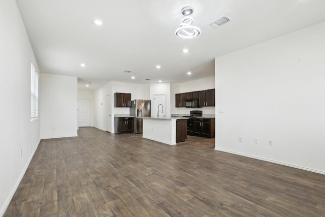 unfurnished living room featuring baseboards, visible vents, dark wood finished floors, a sink, and recessed lighting