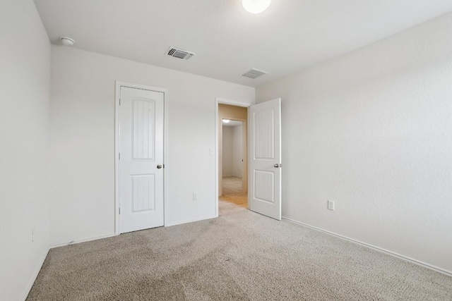 unfurnished bedroom featuring light carpet and visible vents