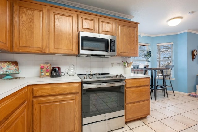 kitchen featuring stainless steel appliances, light countertops, ornamental molding, decorative backsplash, and brown cabinets