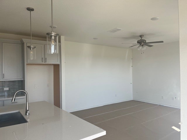 522 Ansley Ct, Taylor, TX 76574 - kitchen featuring a sink, a ceiling fan, tasteful backsplash, light countertops, and decorative light fixtures