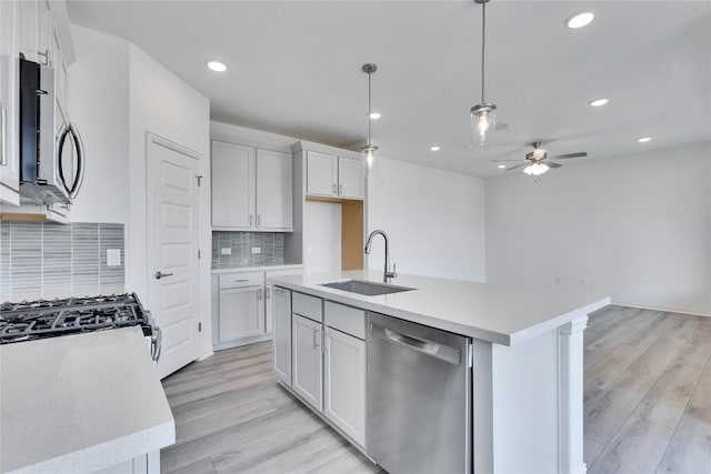 522 Ansley Ct, Taylor, TX 76574 - kitchen with appliances with stainless steel finishes, a ceiling fan, light wood-style flooring, decorative backsplash, and recessed lighting