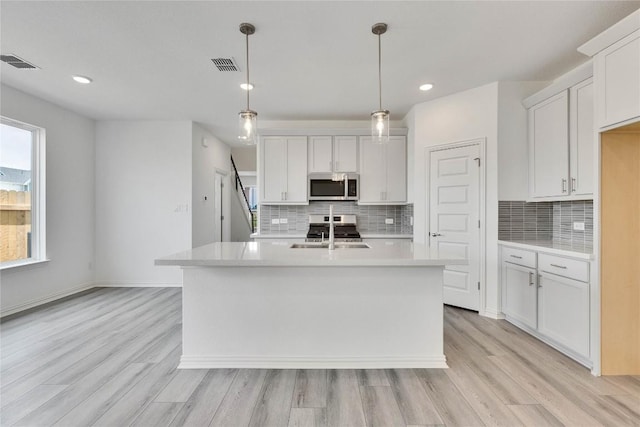 522 Ansley Ct, Taylor, TX 76574 - kitchen featuring stainless steel microwave, light countertops, light wood finished floors, backsplash, and recessed lighting