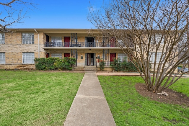 multi unit property with a front lawn and brick siding