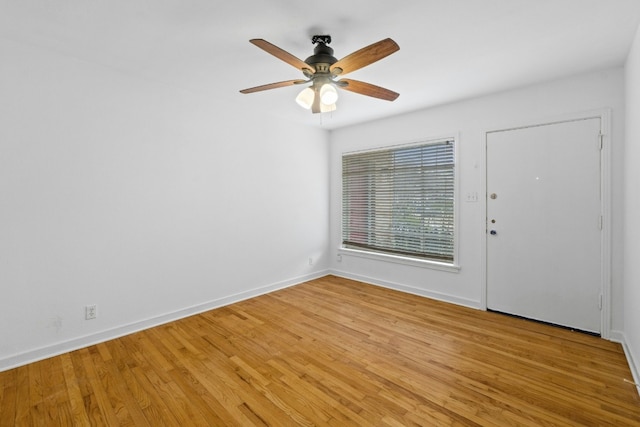 empty room featuring ceiling fan, light wood-style flooring, and baseboards