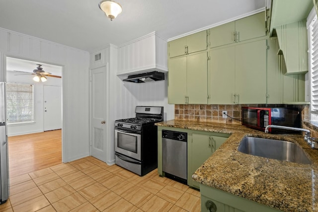 kitchen with a sink, dark stone countertops, appliances with stainless steel finishes, and green cabinetry