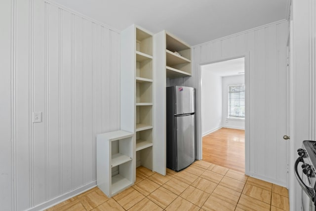 kitchen with black range with gas cooktop, built in features, open shelves, and freestanding refrigerator