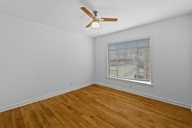 empty room with ceiling fan, baseboards, and wood finished floors