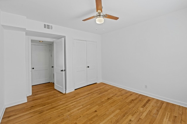 unfurnished bedroom with a closet, light wood-type flooring, visible vents, and baseboards