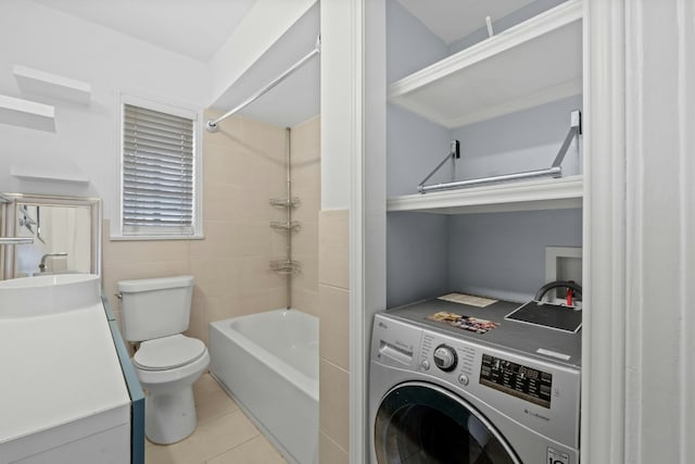 full bath with toilet, washer / clothes dryer, tile patterned flooring, bathtub / shower combination, and a sink