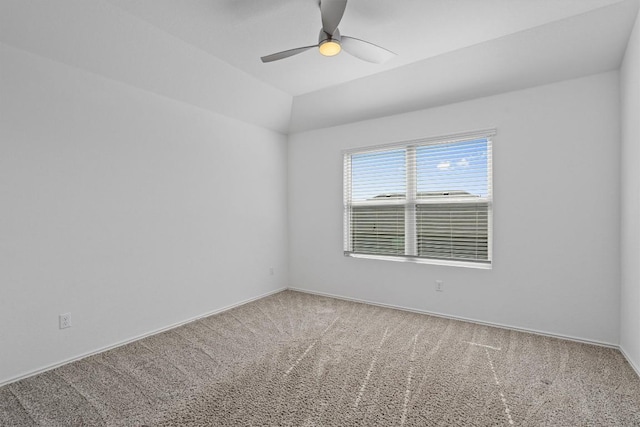 carpeted spare room with a ceiling fan, vaulted ceiling, and baseboards