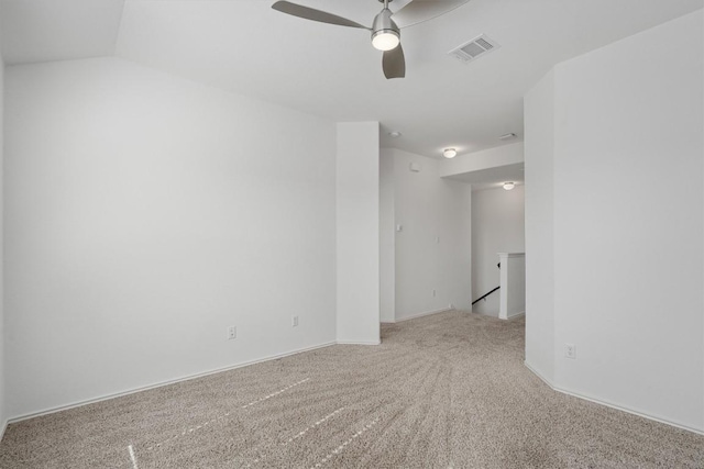 carpeted empty room with lofted ceiling, visible vents, and a ceiling fan