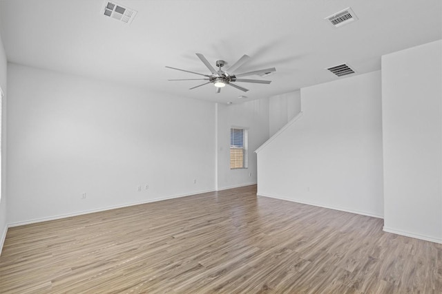 spare room featuring ceiling fan, light wood finished floors, and visible vents