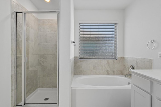 full bath featuring a stall shower, vanity, and a bath