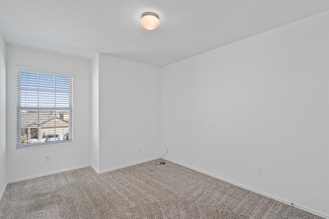 carpeted empty room with baseboards