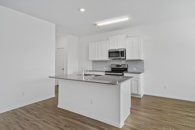 kitchen with dark wood-style flooring, a center island with sink, stainless steel appliances, white cabinets, and a sink