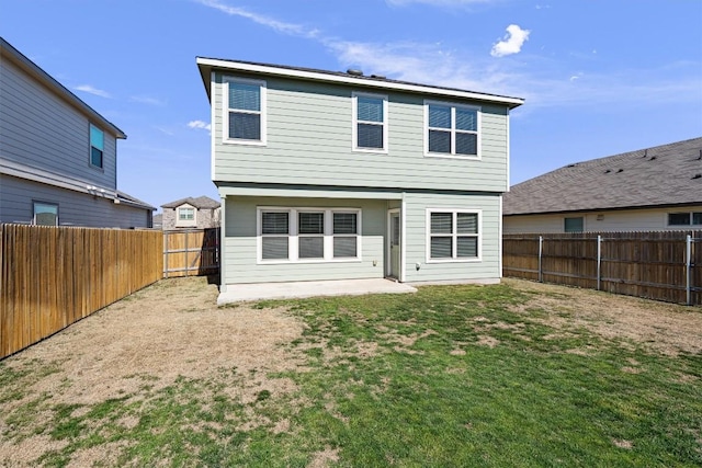 rear view of house featuring a lawn and a fenced backyard